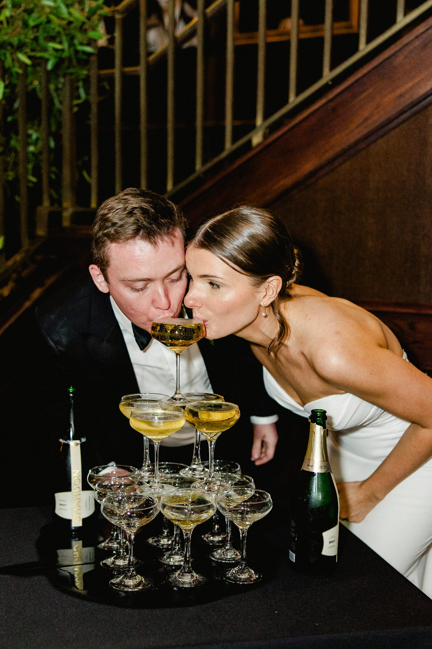 Bride and groom drinking together from the top of a champagne tower at their Tampa wedding reception — Tampa Bay wedding photographer Ailyn La Torre