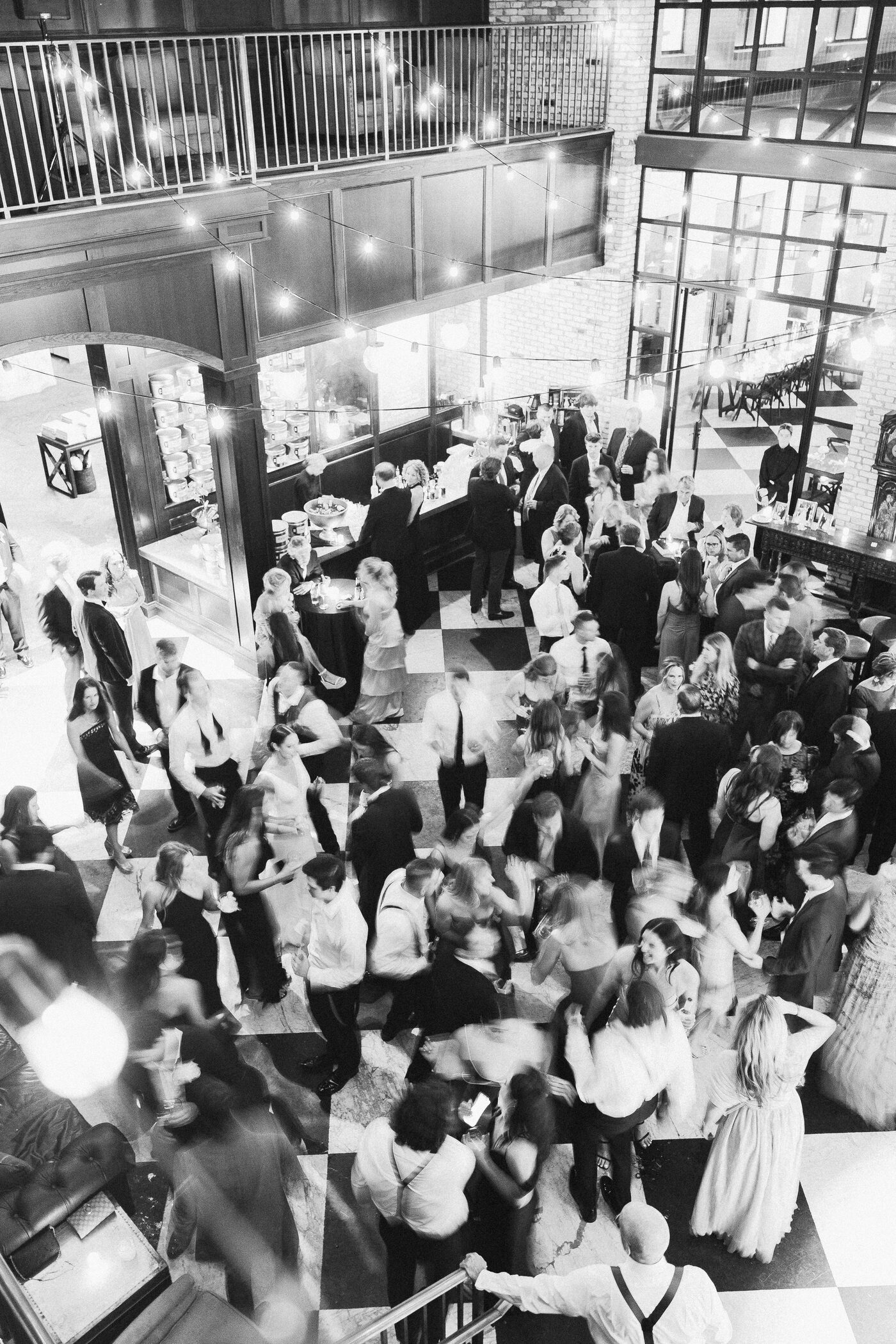 Aerial view of a packed dance floor at an Oxford Exchange wedding reception in Tampa, guests celebrating under warm overhead lights — Tampa Bay wedding photographer Ailyn La Torre